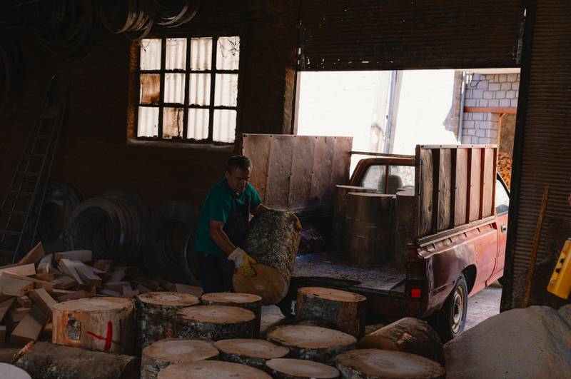 A craftsman's hands carrying the wood from the car