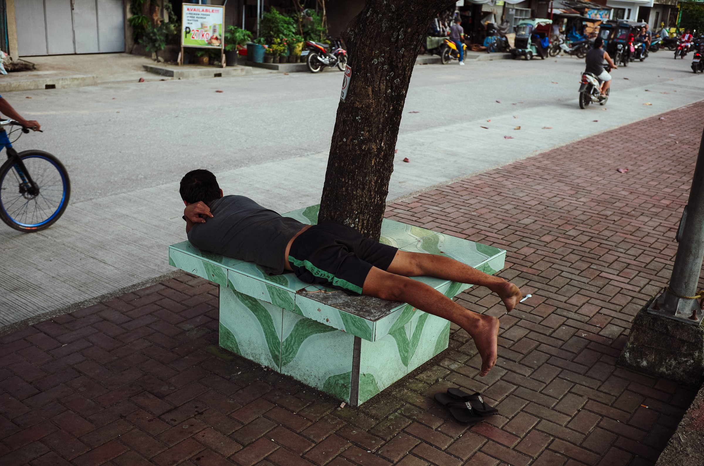 Cinematic night portrait through red-lit window, color street photography by Evangelos Tzemis